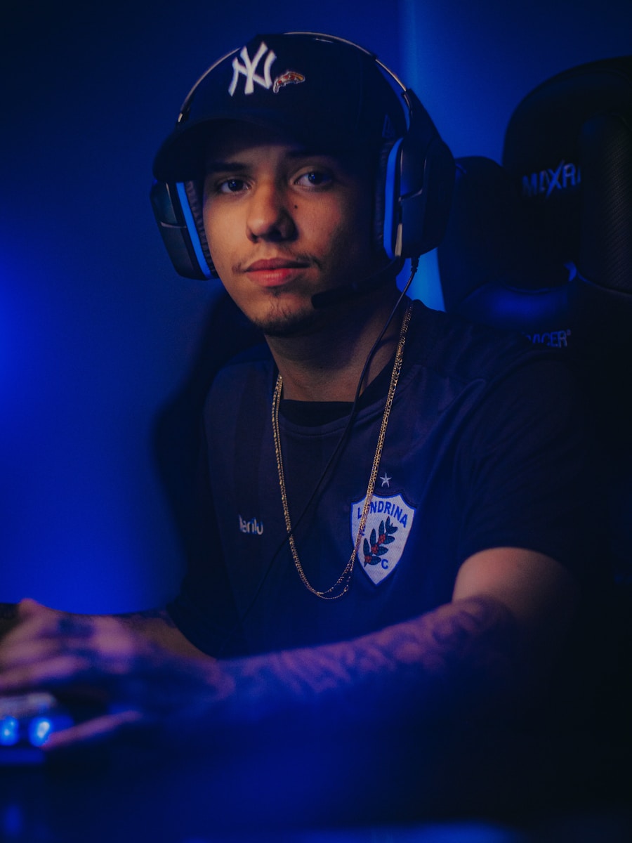 a man wearing a baseball cap sitting in front of a computer